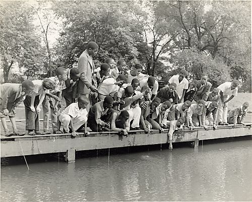Boys in a youth organization learning to fish at a Highland Park pond