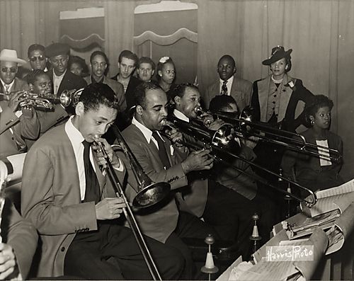 Jazz band, including singers Sarah Vaughan and Ann Baker and trombonist Trummie Young, and members of the Earl Hines Band, with onlookers