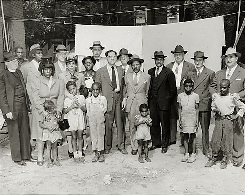 Reverend Harold Tolliver with group standing in front of clothesline