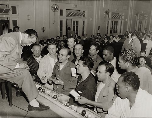 Duke Ellington signing autographs for fans on stage