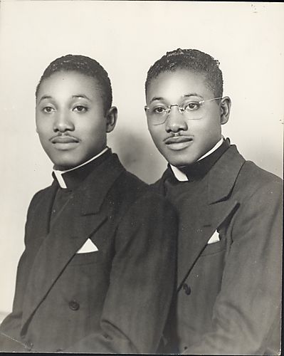 Two young men in minister's collars and jackets
