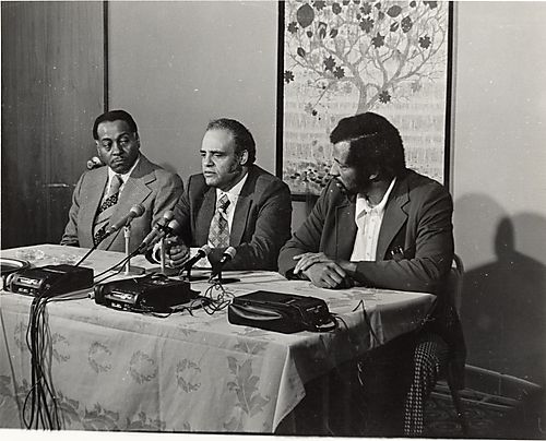 Matthew Moore, Benjamin Hooks, and Roland Saunders at a table with microphones and tape recorders