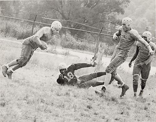 Four football players, with no. 18 on the ground