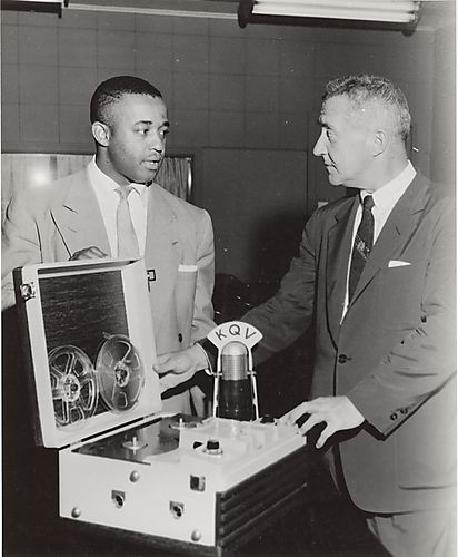 Two men with KQV microphone and reel-to-reel tape recorder in a sound studio