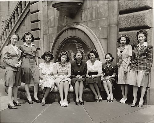 Five women seated and four standing before fountain at the University of Pittsburgh