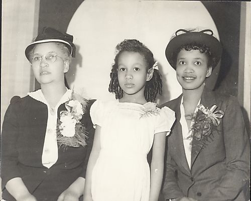 Mrs. Washington, another woman, and a girl in center, all with corsages, posing in Harris studio