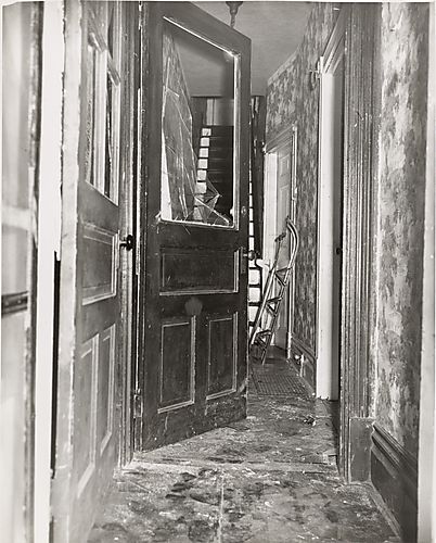Hallway with broken door and sled leaning against wall