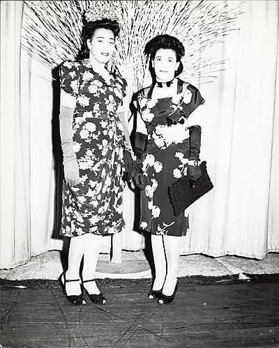 Thelma Foggie Fields and Marietta Foggie Morgan in front of curtain and artificial tree