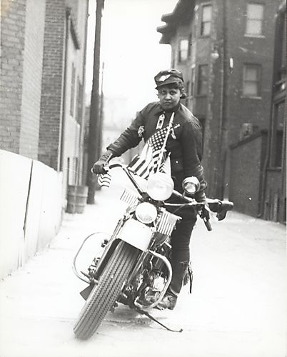 Woman mounting motorcycle decorated with flags