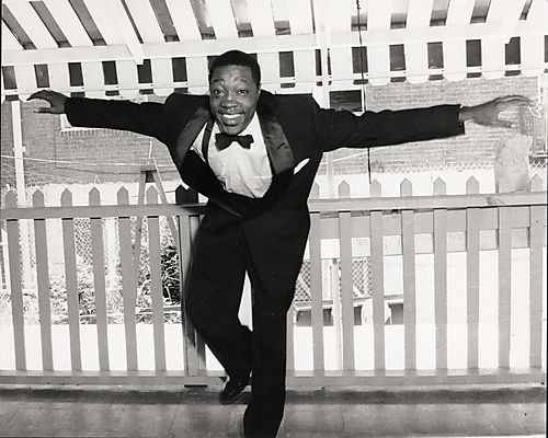 Man in tuxedo dancing on porch
