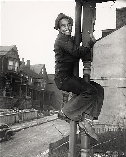 Man climbing wooden pillar of house porch
