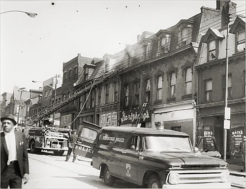 Fire truck and Pittsburgh police car outside Hartzberg's store on Centre Avenue in Lower Hill District