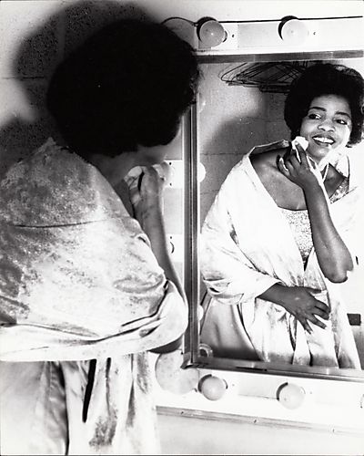 Woman powdering her face before a mirror