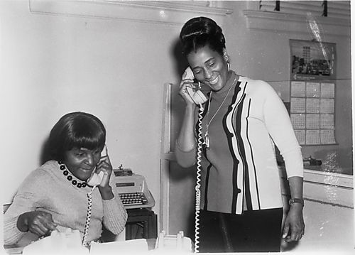Two women on telephones in office