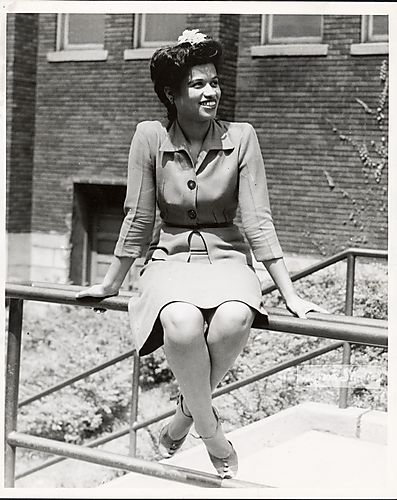 Woman sitting on fence rail