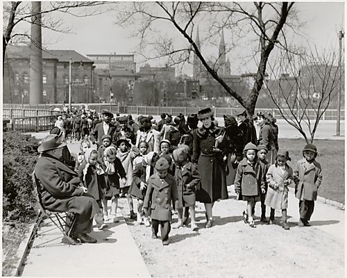 Children in winter coats walking with teacher in Schenley Park, Oakland