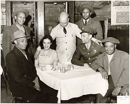 Group at the Harris Grill? on Wylie Avenue, Hill District, including Mr. Asa Harris and his son Sgt. Earl Harris and daughter-in-law Tutty Harris, baseball player Josh Gibson, and Earl Blessitt