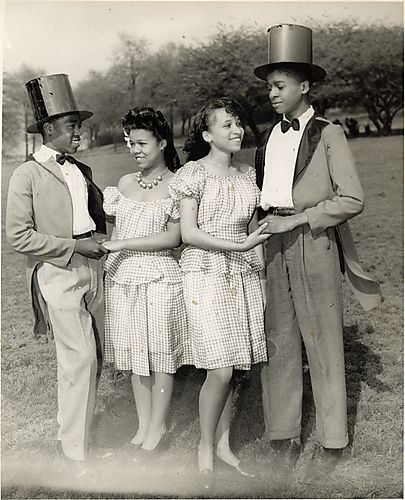 Two girls and two boys wearing matching clothing, posed in park