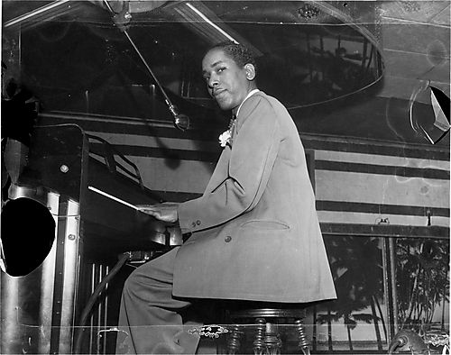 Man playing piano in bar of Crawford Grill No. 2 with tropical murals