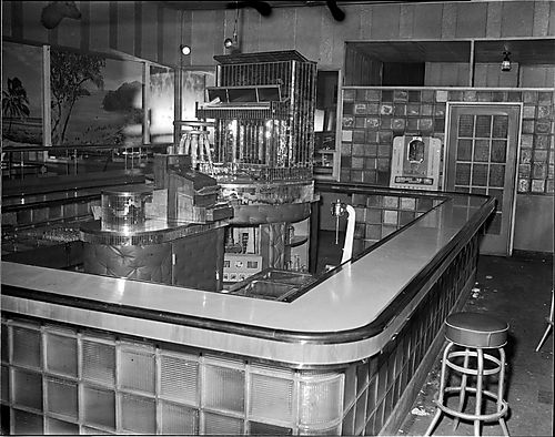 Interior of Crawford Grill No. 2 with tropical murals and mirrored piano on stage in center of bar