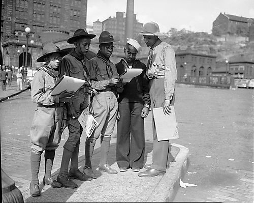 Boy scouts and boy in sailor suit drawing in front of Pennsylvania Railroad Station