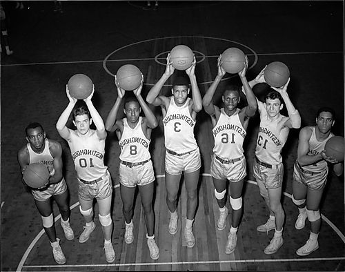 Westinghouse High School basketball team, seven players holding basketballs above head, including #13 Bill Peatross, #16 Ed Fleming, #3 Maurice Stokes, #8 John Miller, and Larry Prunty far right