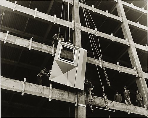 Workmen installing the first aluminum panel