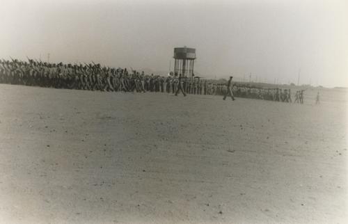 Soldiers Carrying Rifles near Water Tower