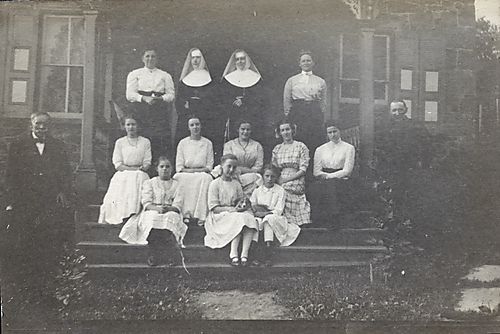 Family posed on the front steps to a house