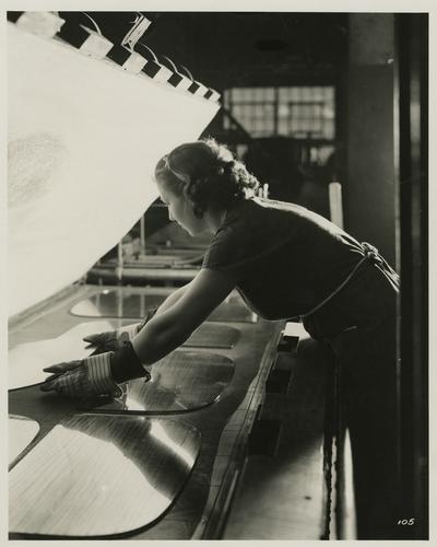 Employee placing Duplate "glass sandwich" in preliminary press