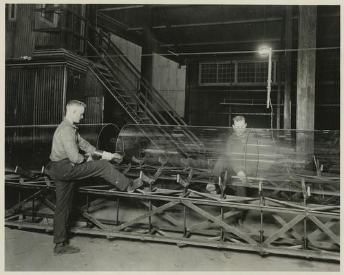 Employees cutting compressed air glass cylinders using hot wire method