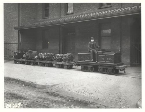 Worker on a shipping trolley carrying machines