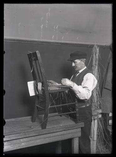 Blind man caning a chair