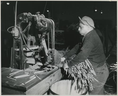 Worker making brooms