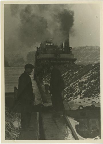 Two men standing on coal barges near the Rezistal