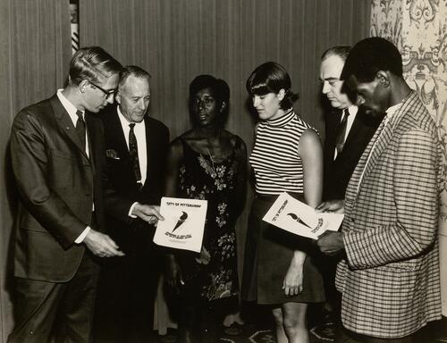 Officials and Athletes Admiring the Youth Olympiad Decals