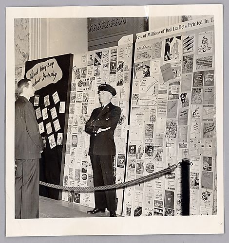 Photograph of a Man Observing a Guarded Wall of Leftist Leaflets