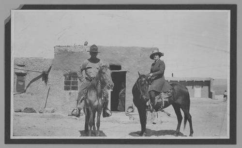 Mary Roberts Rinehart and Dr. Stanley M. Rinehart on horseback, in front of adobe building