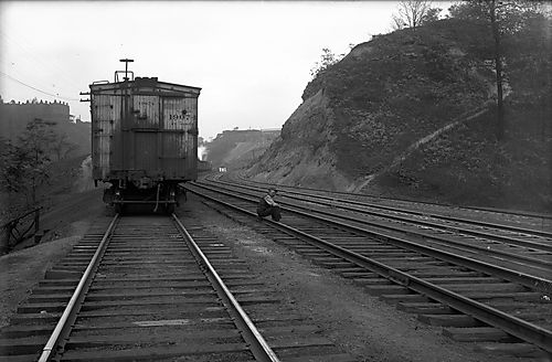 Man Sitting on Railroad Tracks