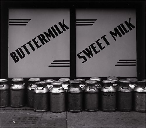 (Signs: Milk Cans in Front of Store)