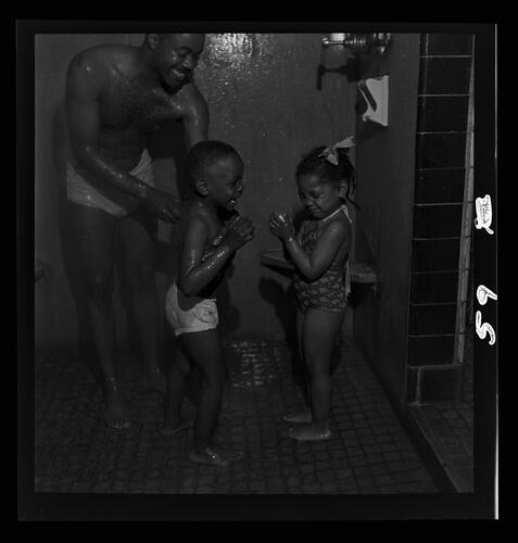 Adult Assists Children in Pool Locker Room