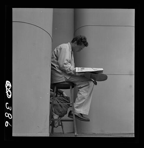 Man Reading on Stool