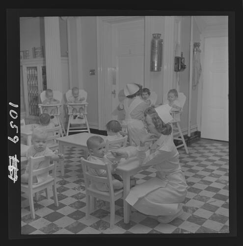 Nurse Feeding Baby at Table