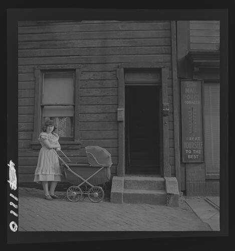 Woman with Baby Carriage on Sidewalk