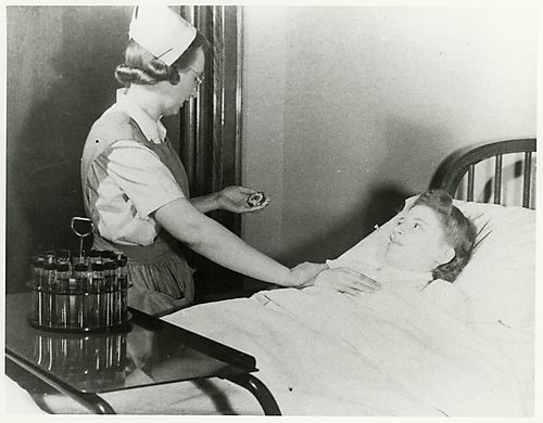 Nurse checking the pulse and temperature of patient