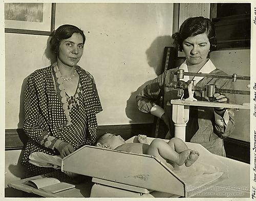 Two Ladies weighing an infant on Better Baby Day