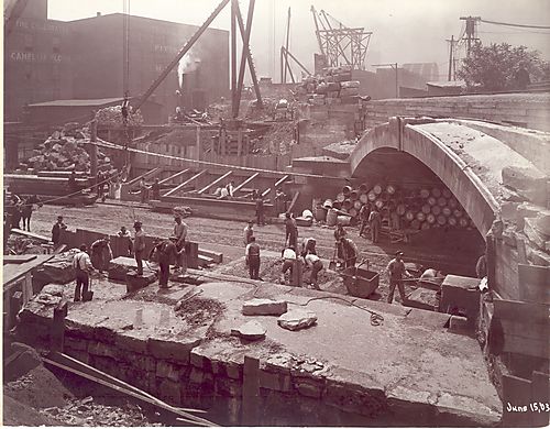 View down to street, barrels under bridge